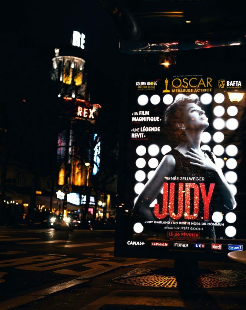 Lebonplanciné - à propos - photo d'une publicité urbaine de nuit. Le film Judy dans la rue Rex à Paris