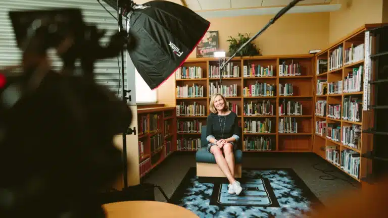 Tournage de séquence vidéo en intérieur avec une bibliothèque en fond de scène pour améliorer la prise de vue vidéo.